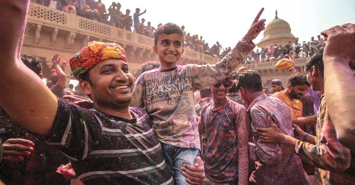 How big is the Holi festival in India? - Man In Black And White Striped Shirt