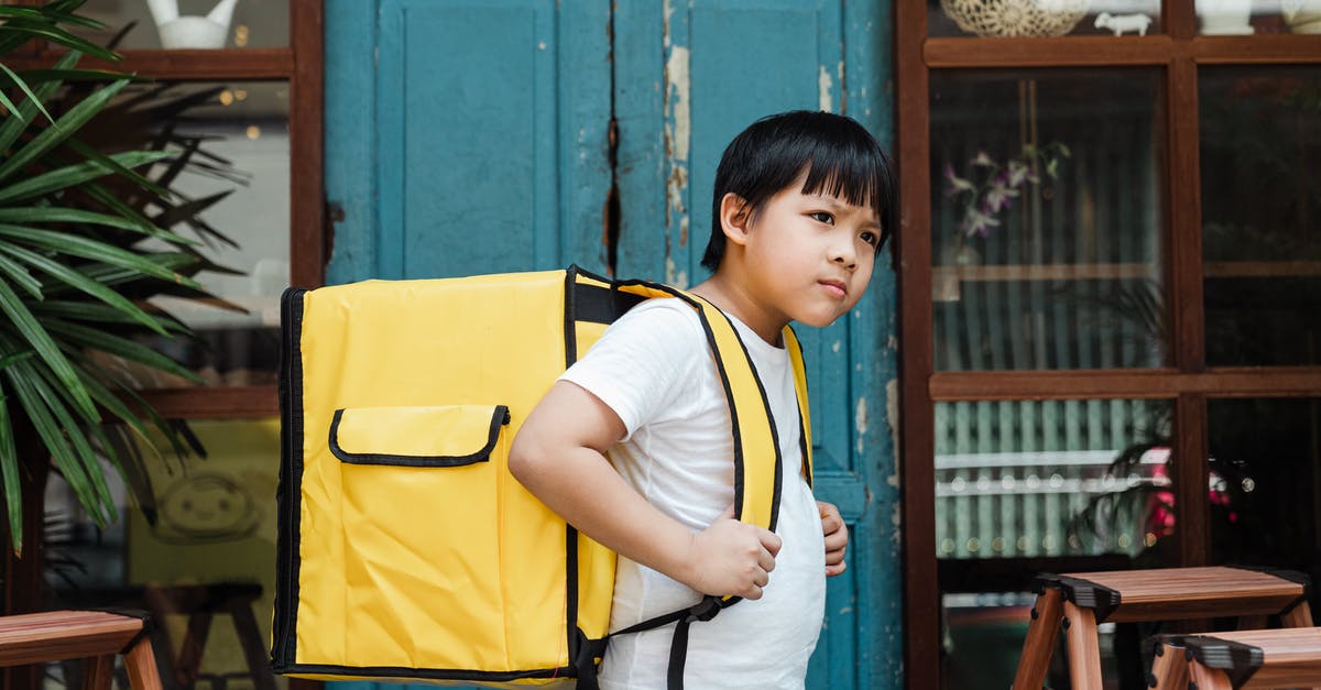 How big of a backpack should I buy? (Trans-Mongolian) - Ethnic boy with heavy food backpack near shabby entrance door