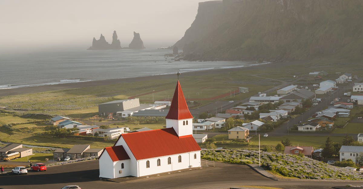 How busy are the Faroe Islands during summer compared to Iceland? - White and Red House Near Road