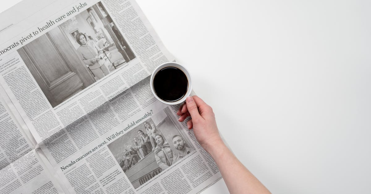 How busy is the Boston to New York Amtrak? - Person Holding White Ceramic Mug on Newspaper