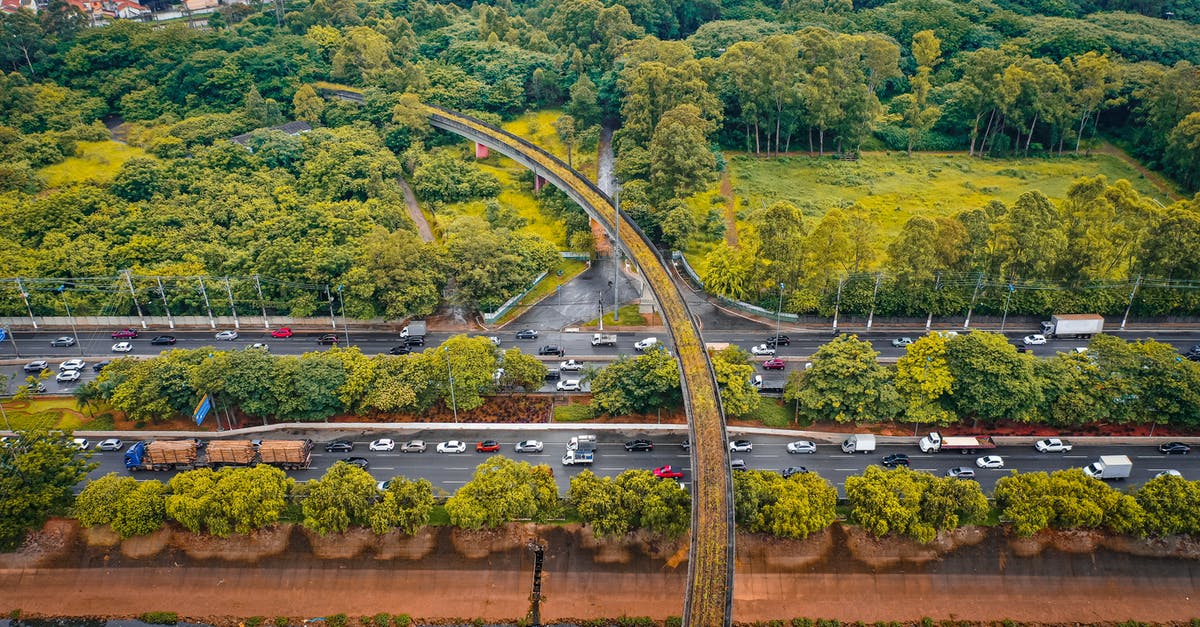 How busy is the E50/D1 motorway in Czech Republic? - Drone view of busy multilane road with driving cars between lush leafy trees in suburban area