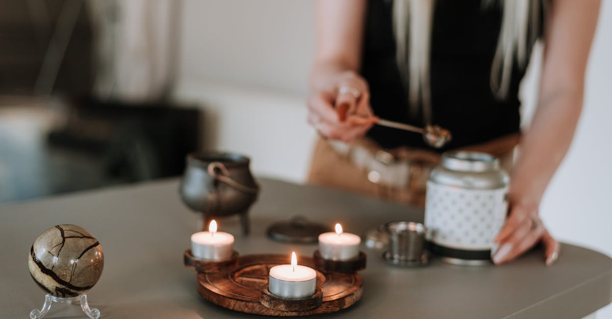 How can I attend an incense ceremony while I'm in Japan? - Woman preparing incense near shiny candles