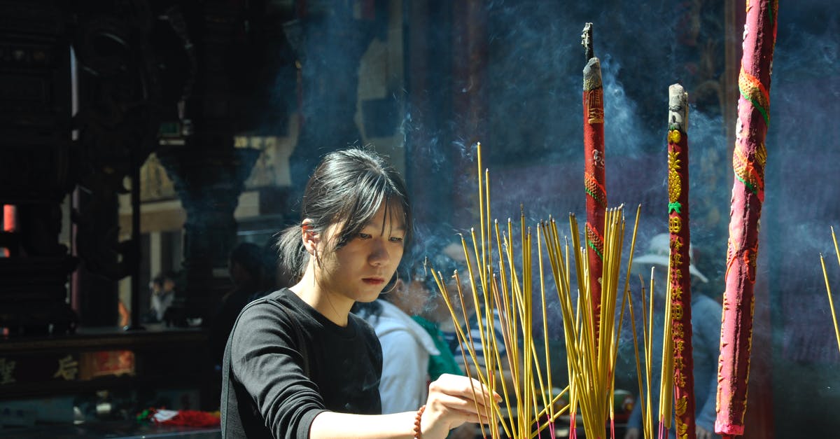 How can I attend an incense ceremony while I'm in Japan? - Woman Lighting Incense Sticks