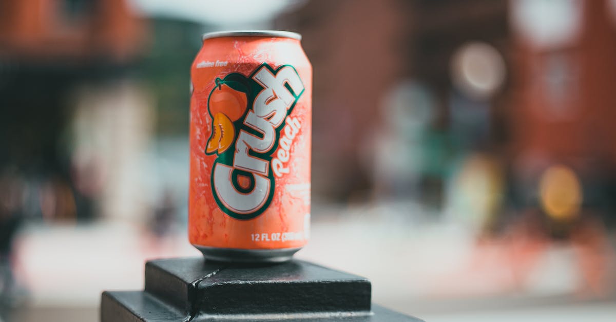 How can I avoid being overcharged when taking a cab? - Orange and White Dr Pepper Can on Black Wooden Table