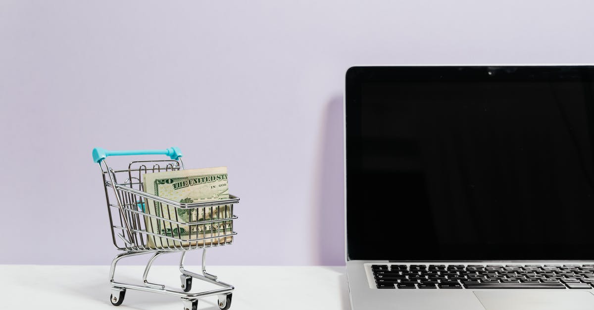How can I buy groceries during a mandatory 14 day quarantine? - Macbook Pro on White Table Beside a Miniature Shopping Cart With Money