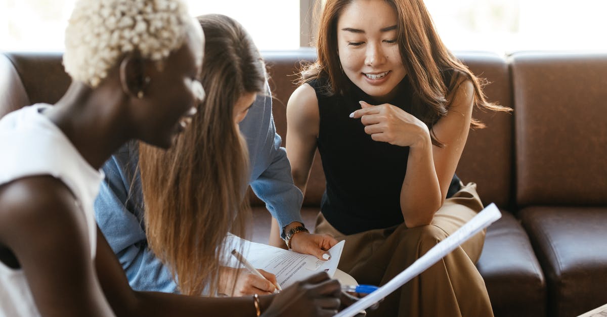 How can I check my status on an American Airlines promotion? - Multiethnic cheerful colleagues talking about job and working with documents