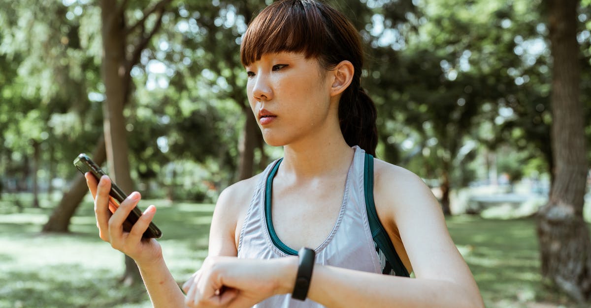 How can I control Internet usage when using in-flight wifi? - Concentrated young Asian woman using smartphone in park