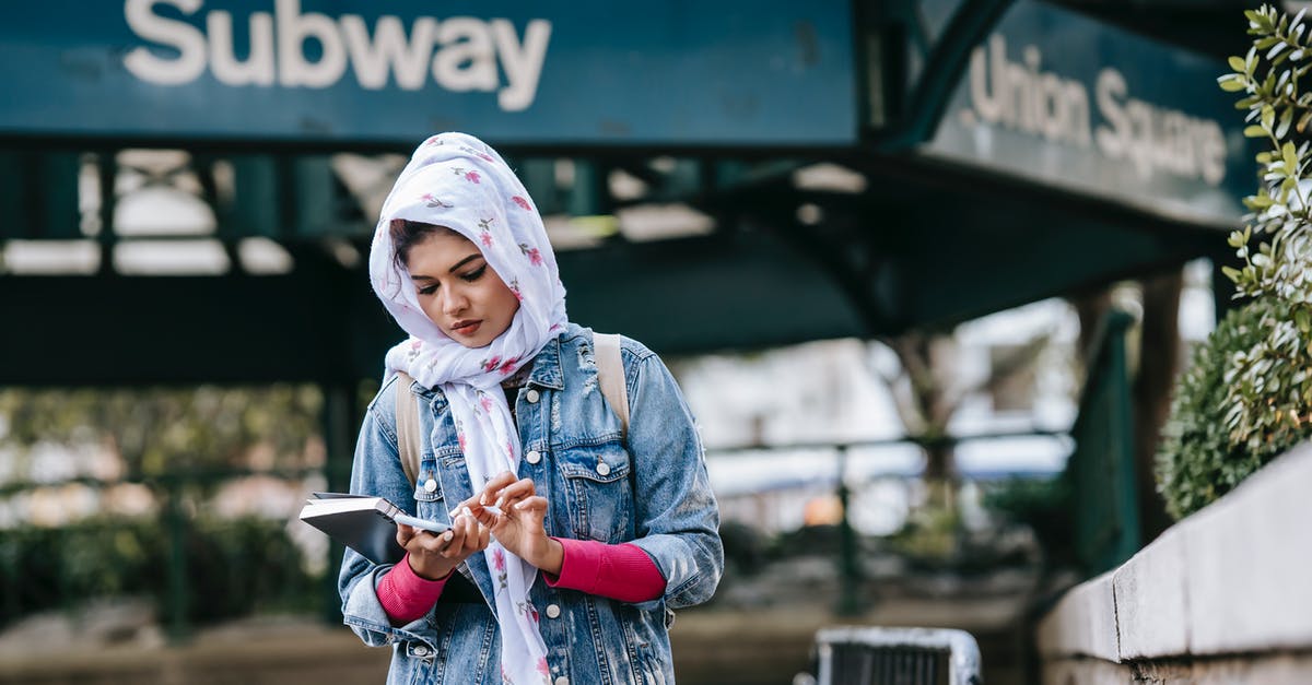 How can I ensure that a specific passport is used for US immigration? - Serious ethnic woman messaging via smartphone while standing near subway