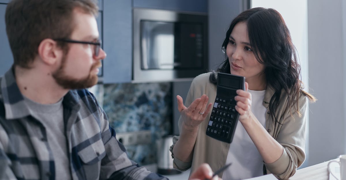 How can I estimate the duration of a long bicycle trip? - Man in Black and White Plaid Dress Shirt Holding Black Smartphone