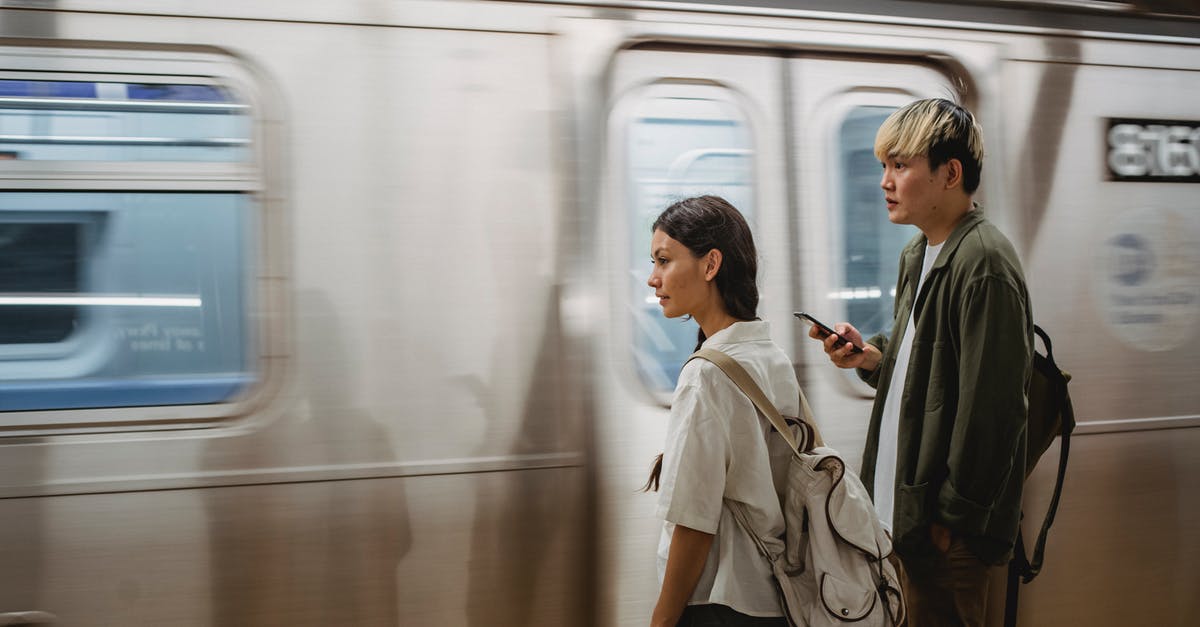 How can I find my train platform number at Zurich? - Calm Asian couple standing on train platform