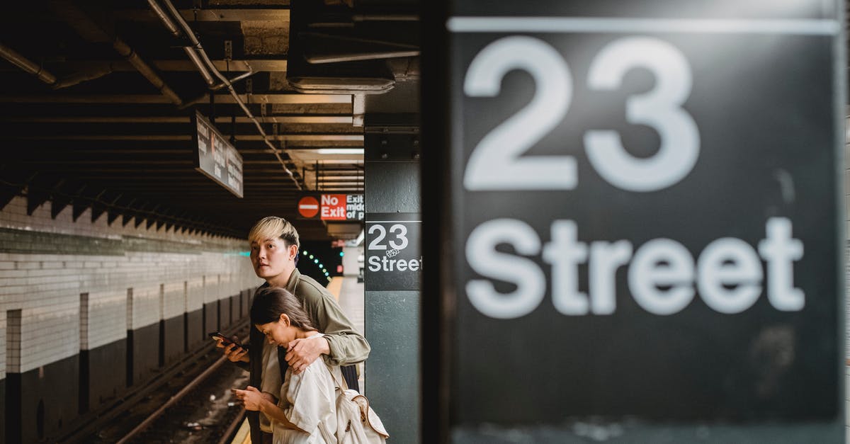 How can I find my train platform number at Zurich? - Asian couple standing on railroad station