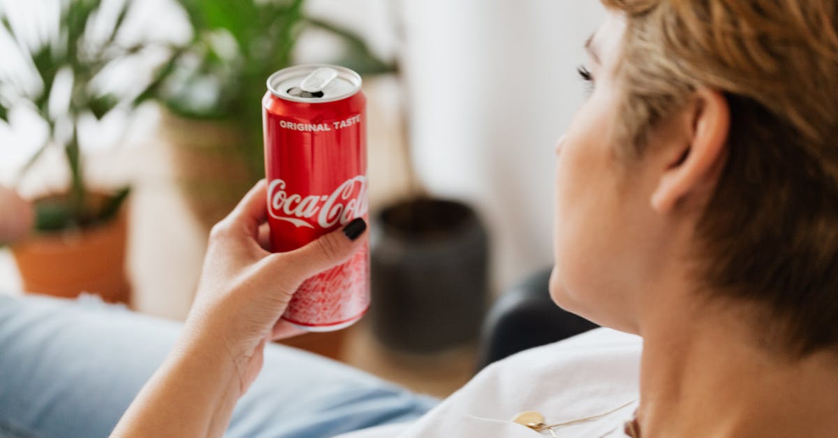 How can I find short-term private room accommodations in London? - Crop anonymous woman resting at home with can of coke