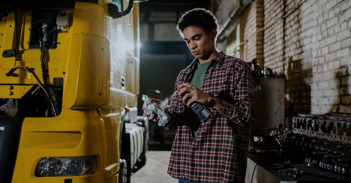 How can I find Turkish truck stops in Greece? - Man Wearing Plaid Long Sleeves Polo Holding a Spray Can