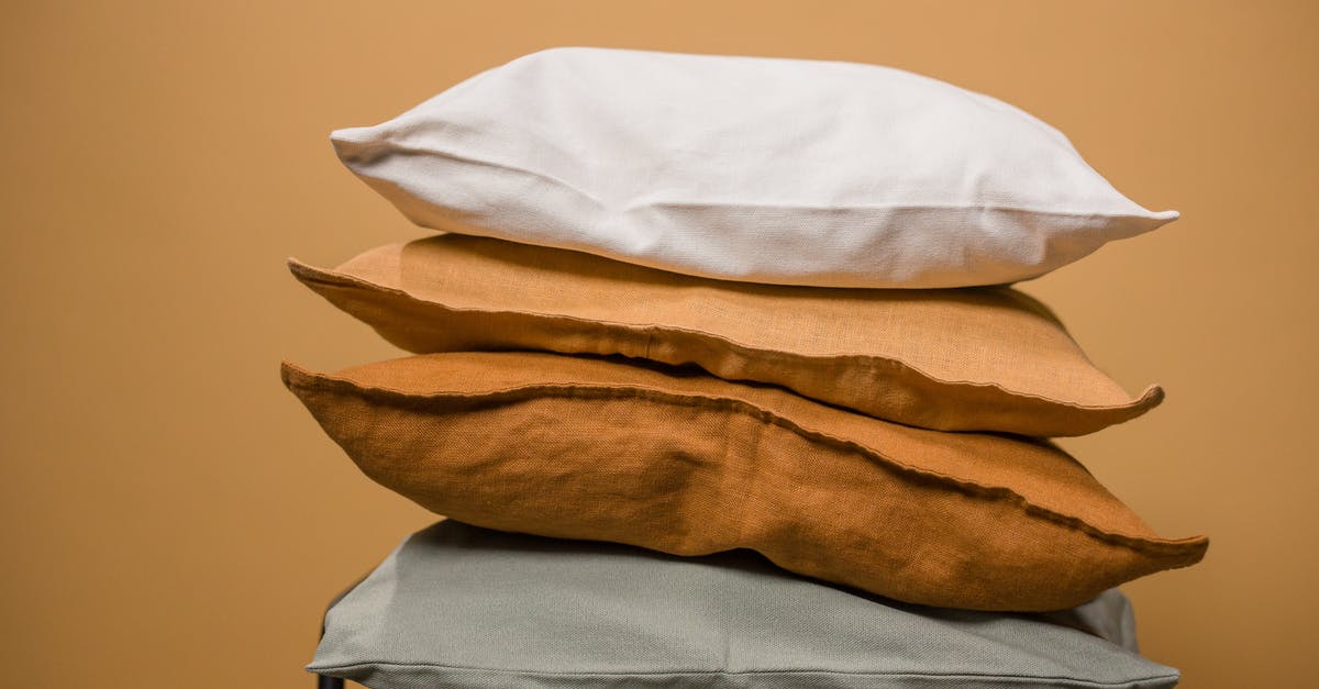 How can I get a different seat after boarding a flight? - Stack of different colorful pillows folded and placed in stack on chair isolated on dark beige background