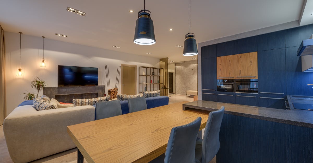 How can I get a different seat after boarding a flight? - Interior of modern lounge with kitchen illuminated with lamps in comfortable spacious apartment