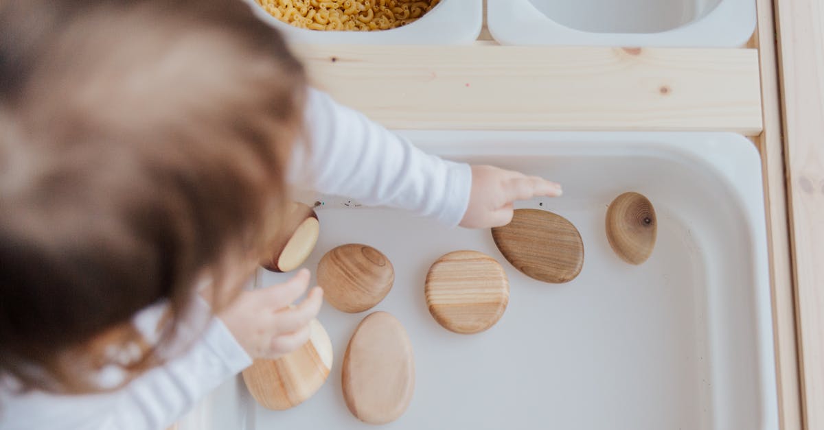 How can I get from Heathrow T5B to T5A? - Crop anonymous child getting brown stones from white container at home