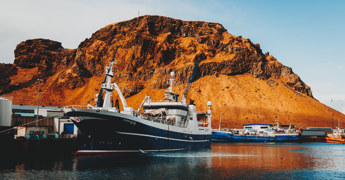 How can I get to Iceland on a cargo ship? - Vessels on seashore in port on sunny day