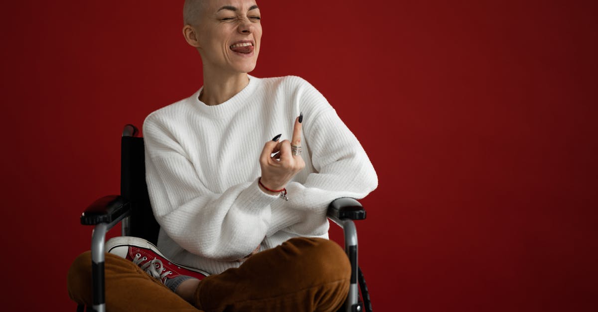 How can I make flying with a wheelchair or crutches easier? - Female in wheelchair grimacing with tongue out and middle finger