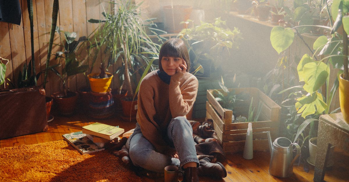 How can I make my boots less of a nuisance in the airport? - A Woman Sitting on the Floor Near a Wooden Crate With Potted Plants