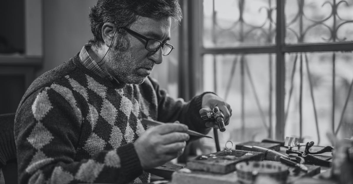 How can I repair my old and expired passport? - Grayscale Photo of Man Holding Tools