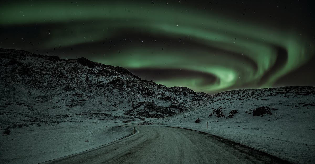 How can I travel to the North Pole, cheaply? - Snow-Covered Mountains Under Aurora Borealis