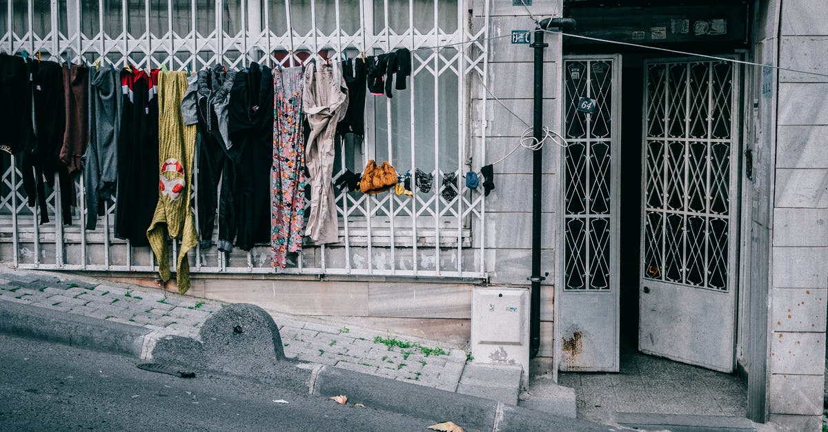 How can I wash my clothes in Lviv, Ukraine? - Laundry drying on clothesline near condominium entrance