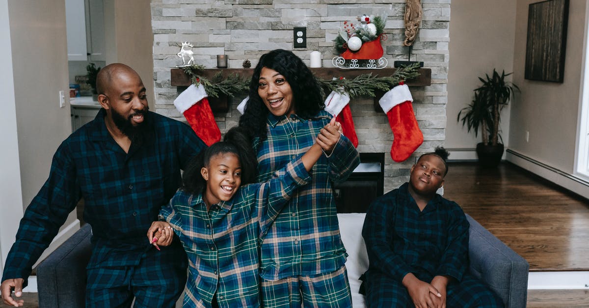 How can two airlines have the same IATA code? - Cheerful African American family in same clothes gathering in cozy living room decorated with Christmas stockings