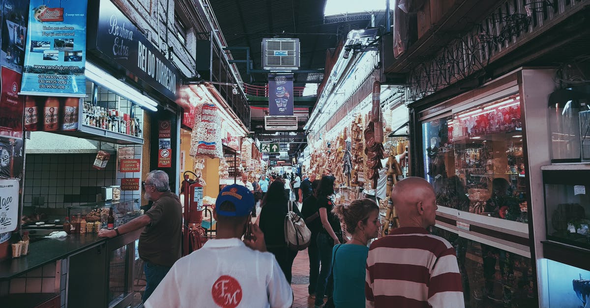 How can you buy tourist souvenirs for non-tourist prices? - People Shopping At Stores In An Alley