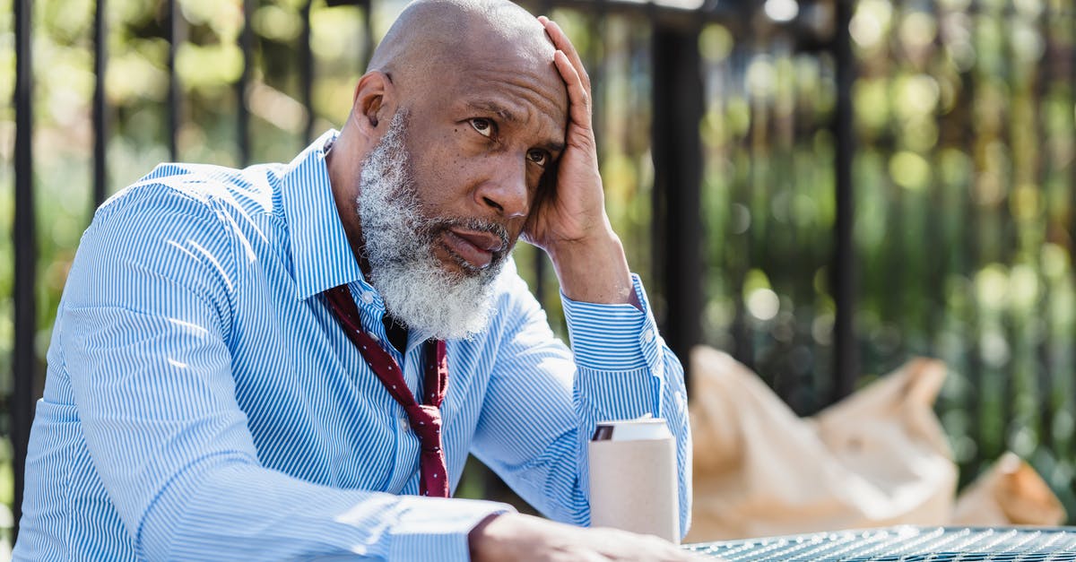 How can you reach Amadeus on behalf of American Airlines? - Thoughtful African American man sitting at table with tin can