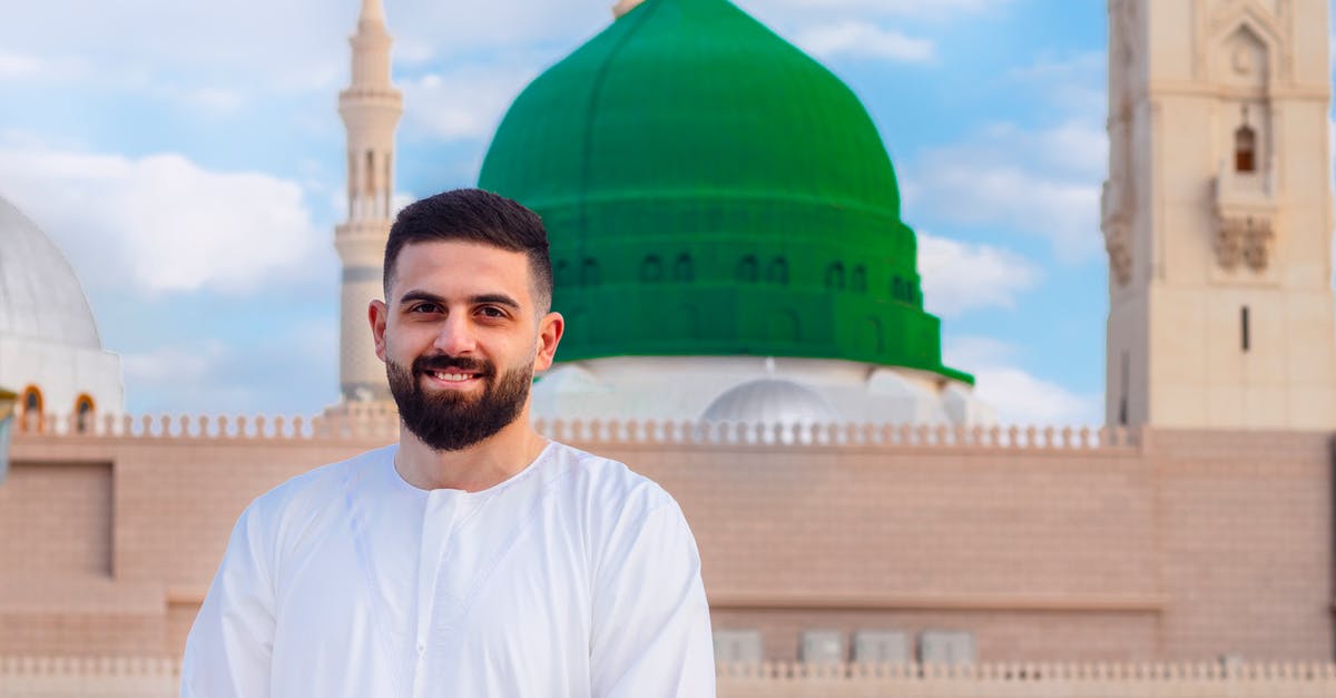 How cheap are the cheapest accommodations in Saudi Arabia? - Man In White Long Sleeve Shirt Standing Near A Mosque