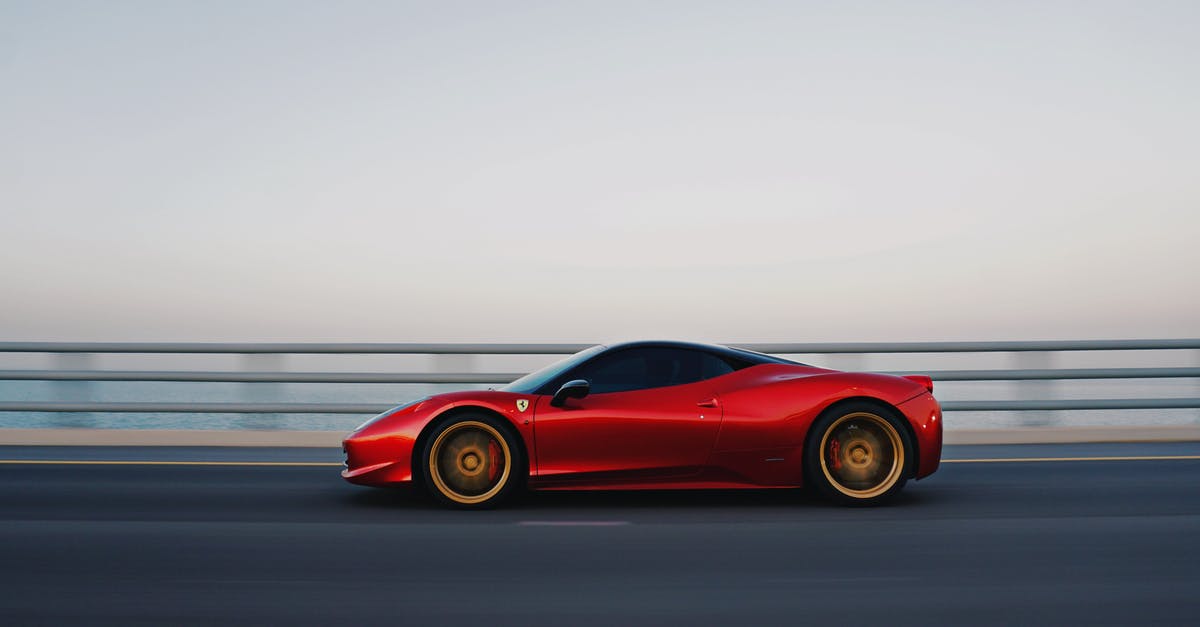 How could a Washington registered car travel to Zürich? - Red car driving on road along fence