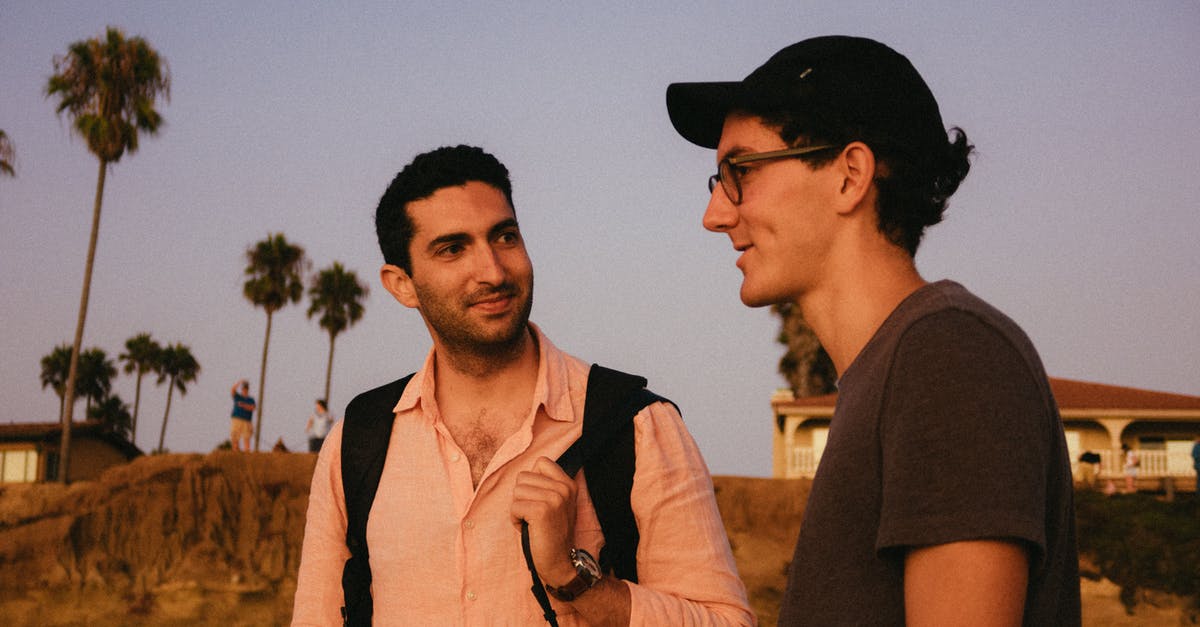 How do I avoid conversation with strangers while traveling? - Photo of Men Talking With Each Other