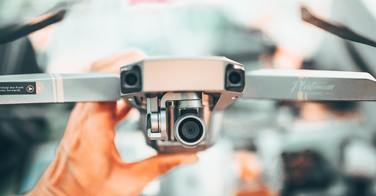 How do I check-in for a flight using an e-ticket? - Faceless man checking drone with video camera on urban background in modern city in soft daylight