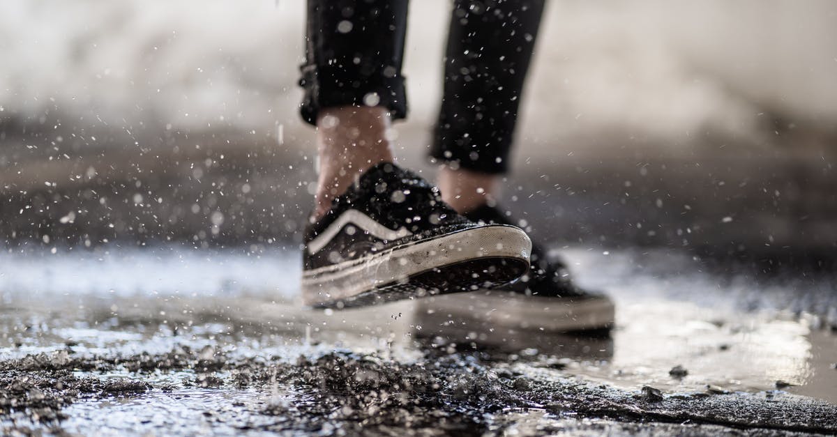 How do I create all-inclusive travel packages for a wedding? - Crop person walking through puddles on asphalt