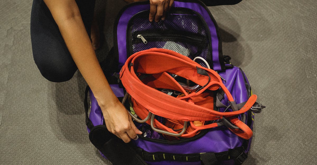 How do I get from Berlin to Tromsø? - Crop woman getting safety equipment from violet bag