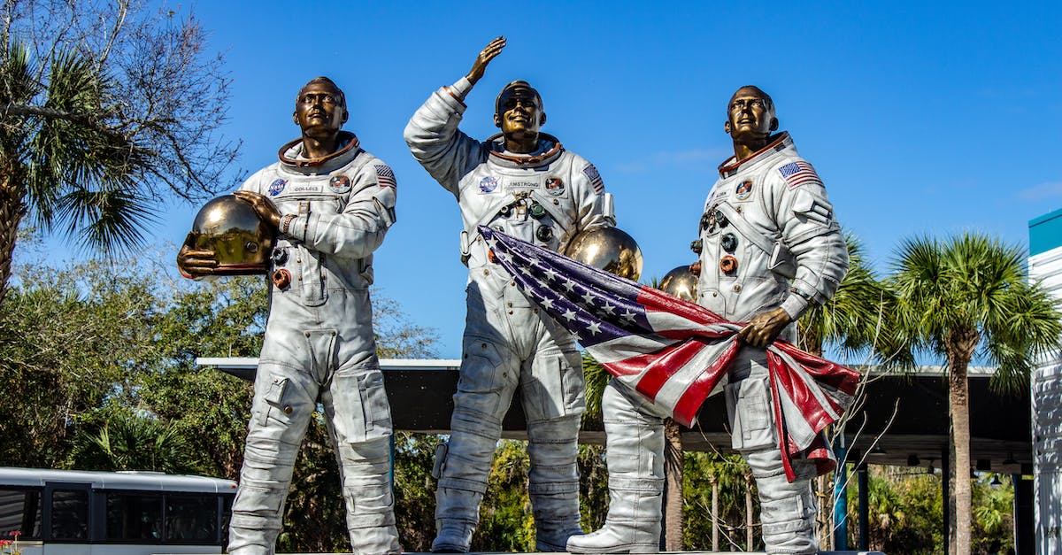 How do I get to Cape Canaveral from Orlando? - People in Gold and White Costume Standing on Gray Concrete Bridge