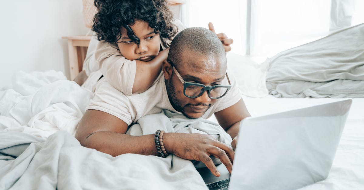How do I identify an airport’s official free Wi-Fi network? - Focused black man with kid surfing laptop on bed How do I identify an airport’s official free Wi-Fi network? - Focused black man with kid surfing laptop on bed