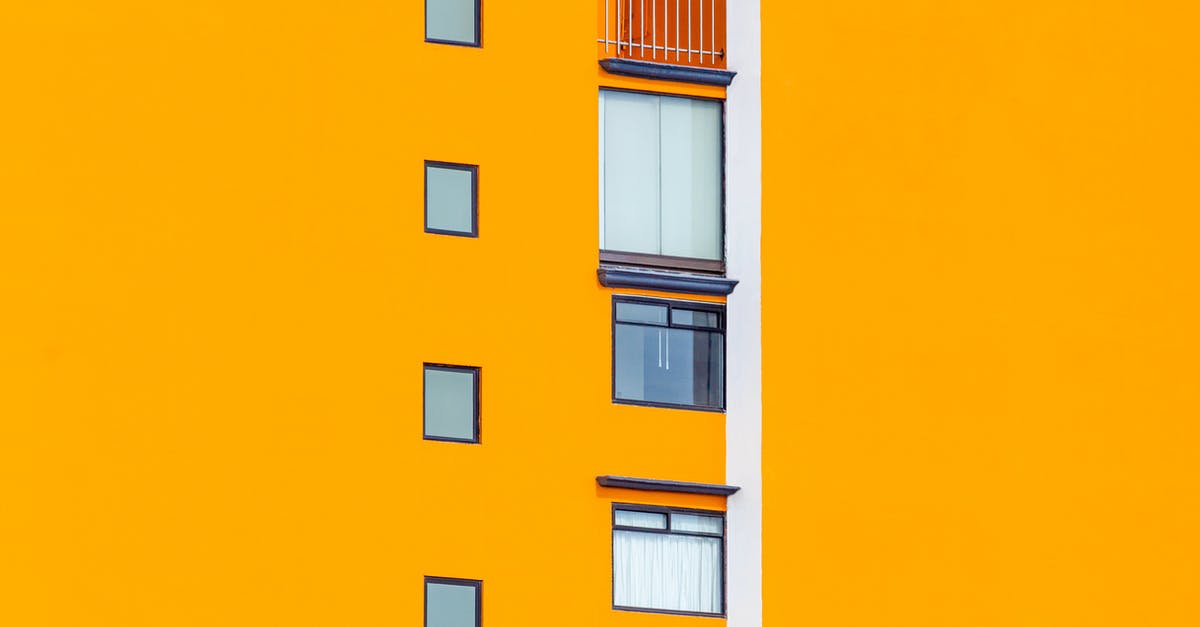 How do I rent a small bus in Buenos Aires? [closed] - Facade of residential house with bright orange wall with small glass glass windows in daylight in street in city outside