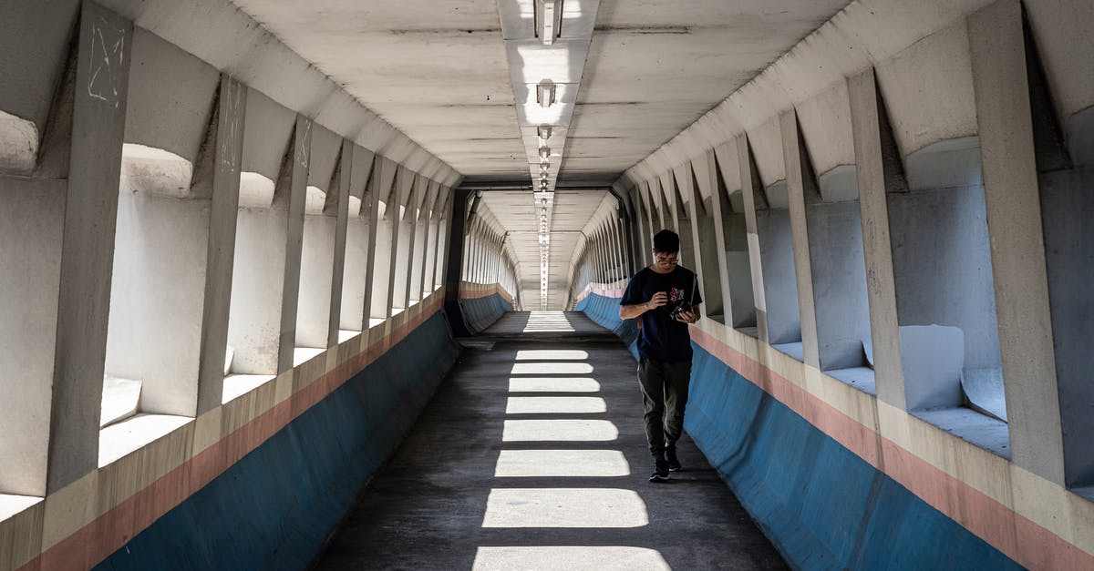 How do I use the Hong Kong-Zhuhai-Macao (HKZM) bridge? - Man Walking Inside a Foot Bridge