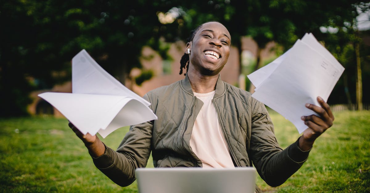 How do North Americans use toilet paper? [closed] - Happy African American man holding sheets of paper in front of laptop
