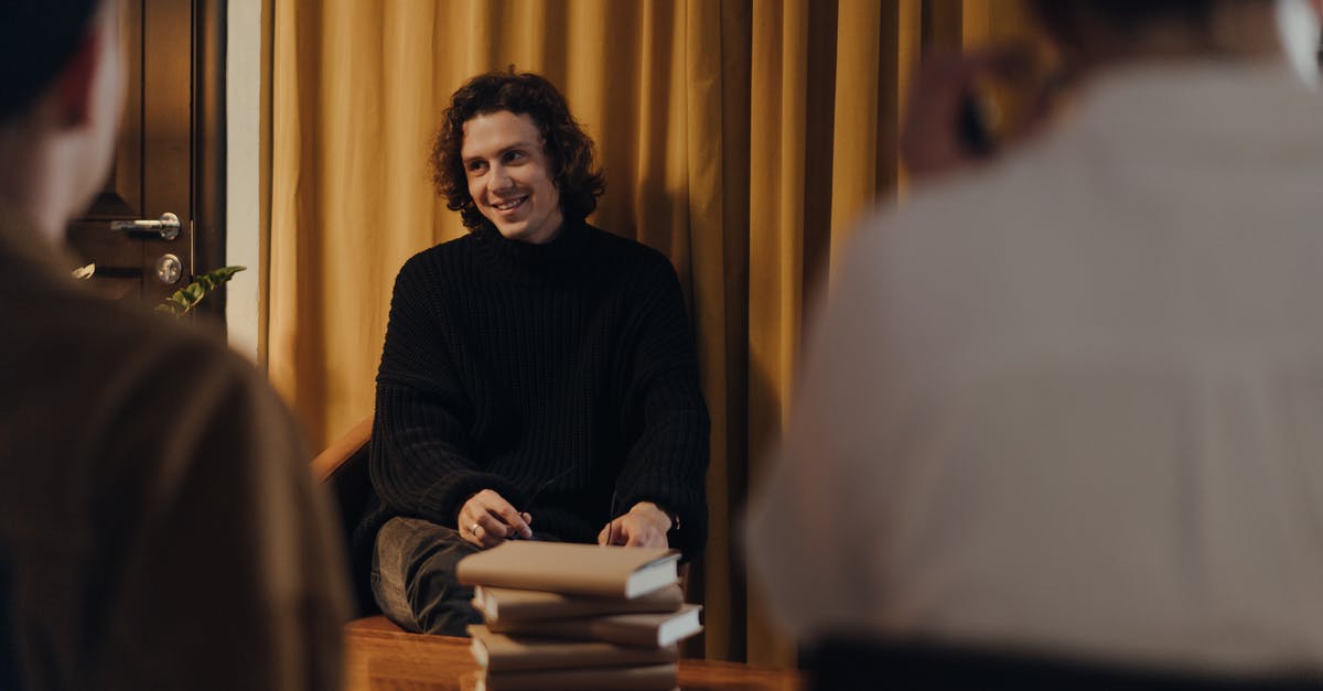 How do tour companies book flights and hotels? [closed] - Man in Black Sweater Sitting on Chair