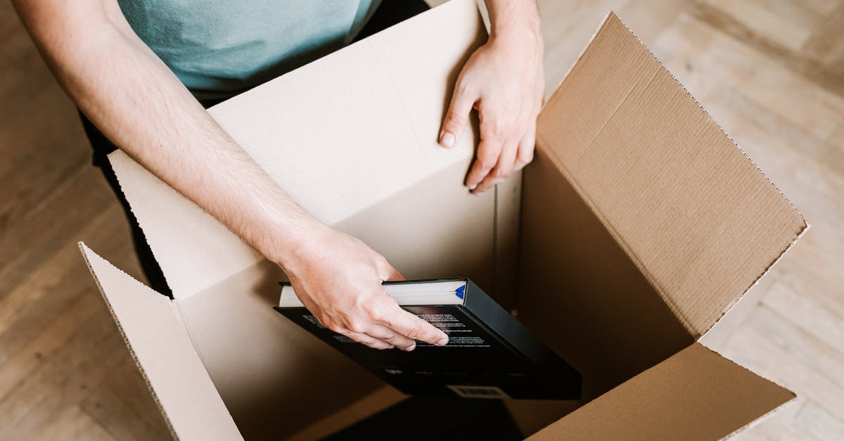 How do you book an Emirates Dubai stopover package (from US/Canada)? - Crop man packing books in carton box