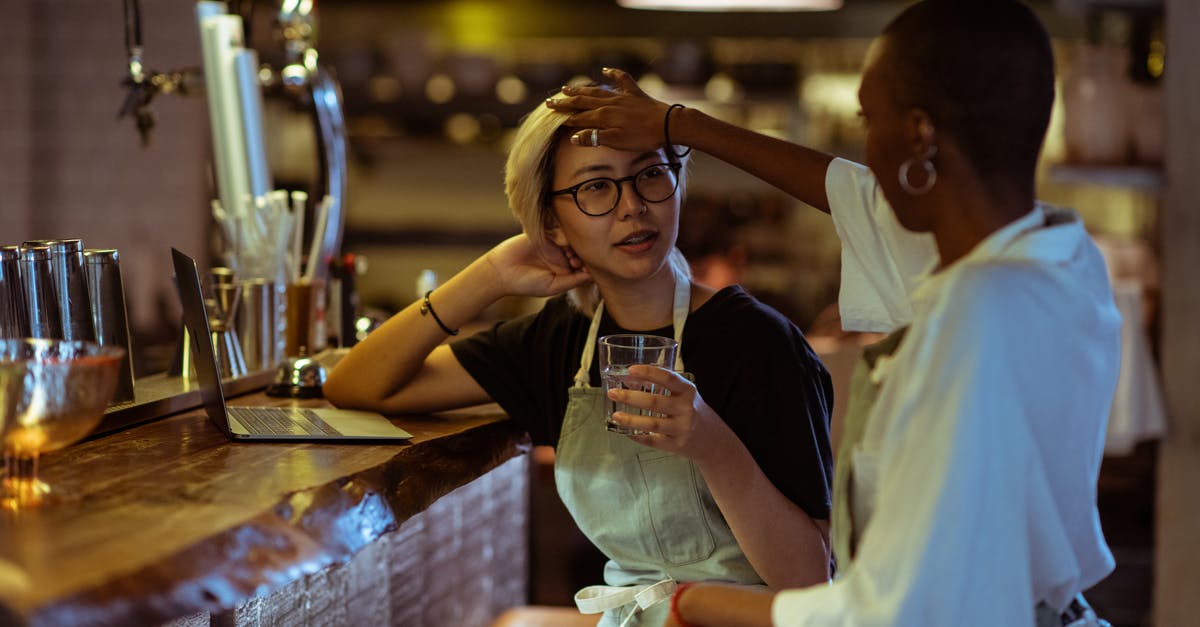 How do you choose a restaurant when travelling? - Content bar workers gathering with laptop at bar counter