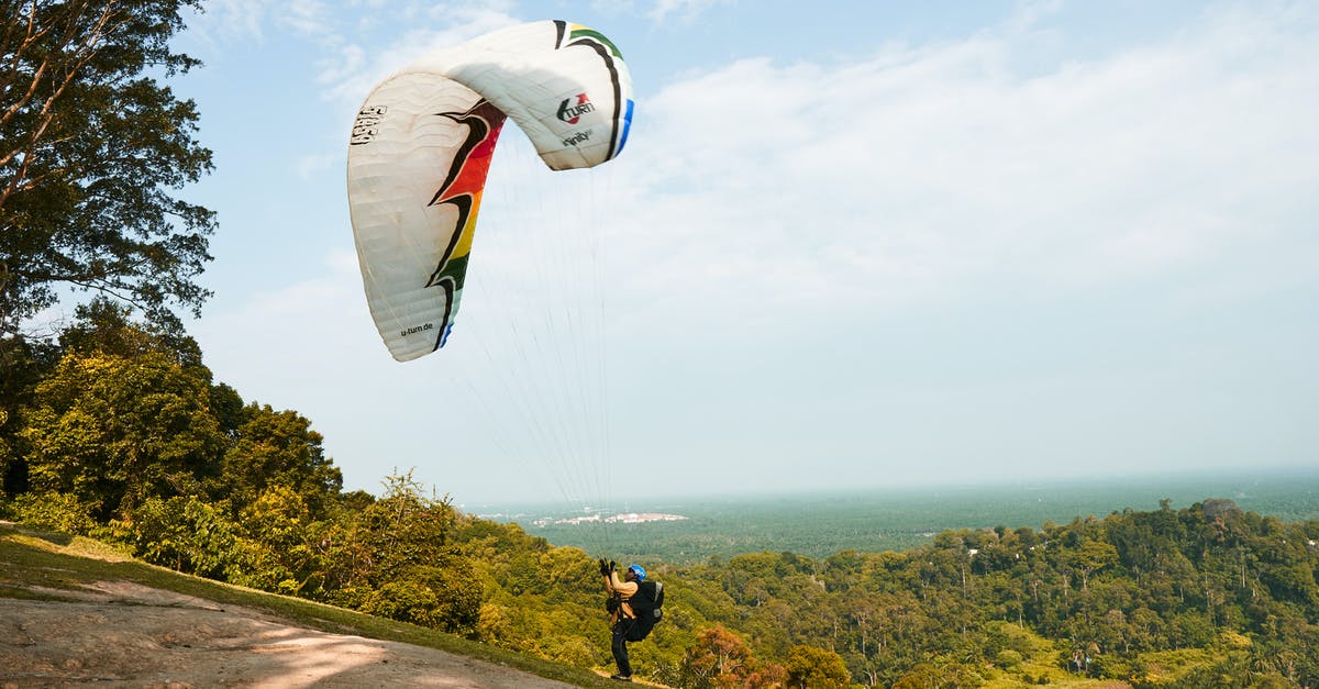 How do you get air miles? - Man Holding Onto Parachute