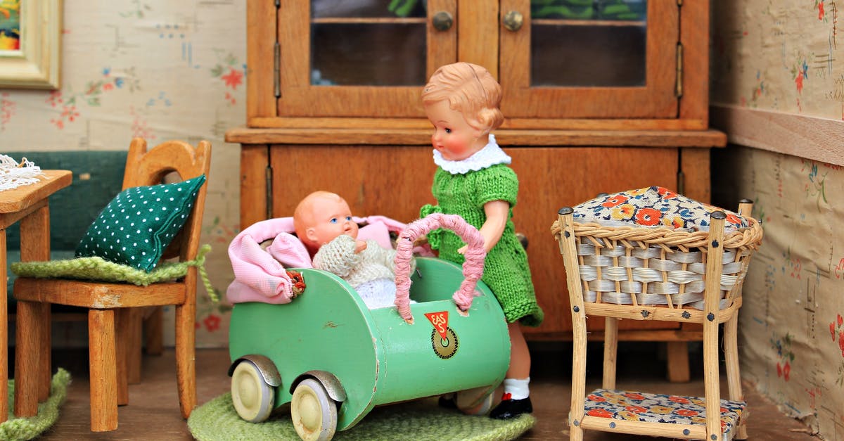 How do you seat a baby securely on a coach transfer? - Brown Haired Girl Doll Holding Baby in Bassinet Doll