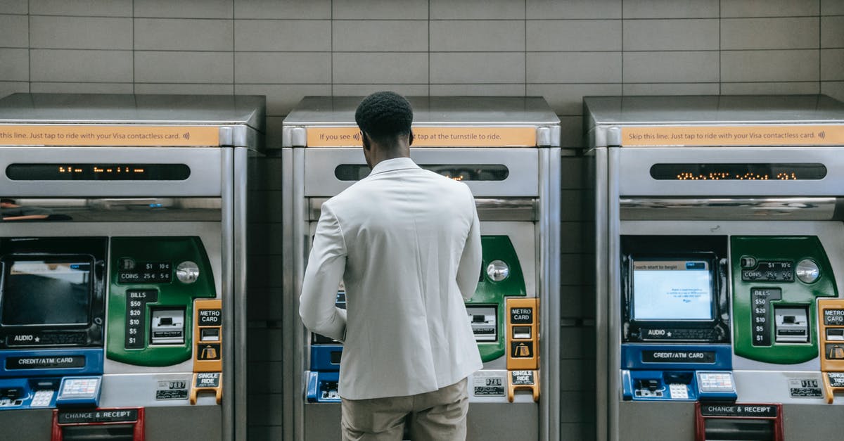 How do you use ATM machines abroad? [closed] - Man Standing in front of a Machine