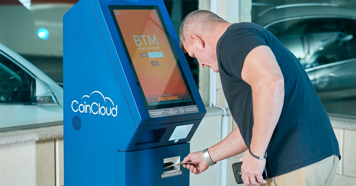 How do you use ATM machines abroad? [closed] - Man in Black Shirt using an ATM