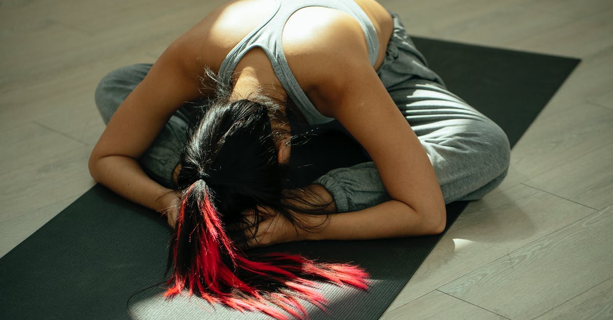 How does Eurostar segregate Brussels-bound and London-bound passengers from the Netherlands? - From above full body of anonymous flexible female with long dyed hair bending forward while practicing Baddha Konasana B yoga pose on mat in studio