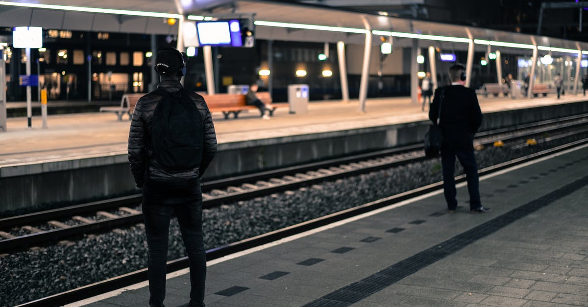 How does Eurostar segregate Brussels-bound and London-bound passengers from the Netherlands? - Photo of Two Men Standing Near Railway Station 