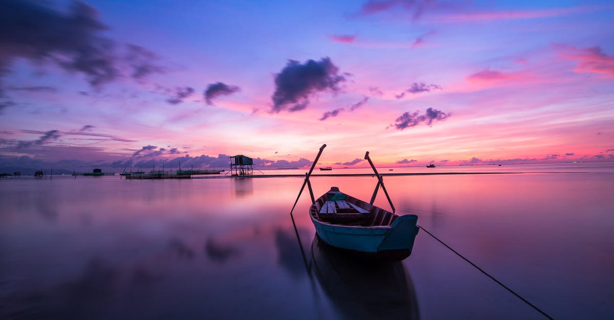 How does the weather compare between Bali and Vietnam in April? - Blue and White Boat on Body of Water